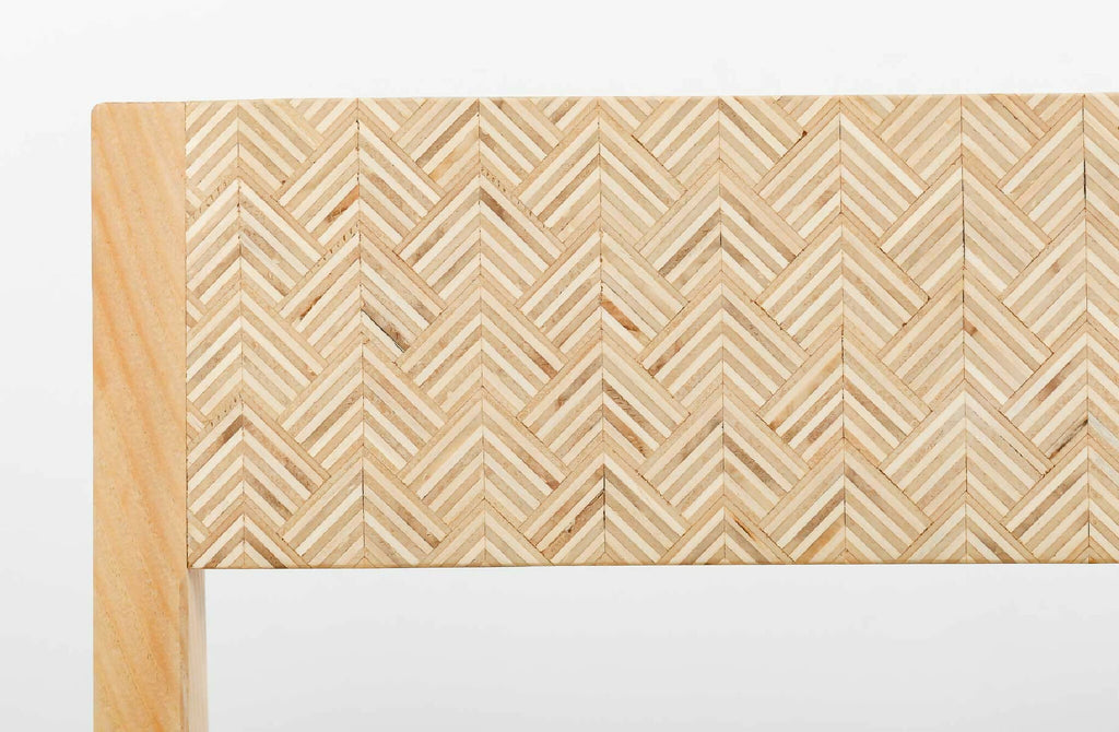 Détail du dossier : tissu beige à motif chevrons, finition bois claire en bordure.