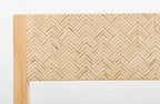 Détail du dossier : tissu beige à motif chevrons, finition bois claire en bordure.