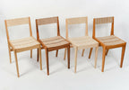 Ensemble de 4 chaises en bois, dossiers et assises avec panneaux beige à motifs chevrons.