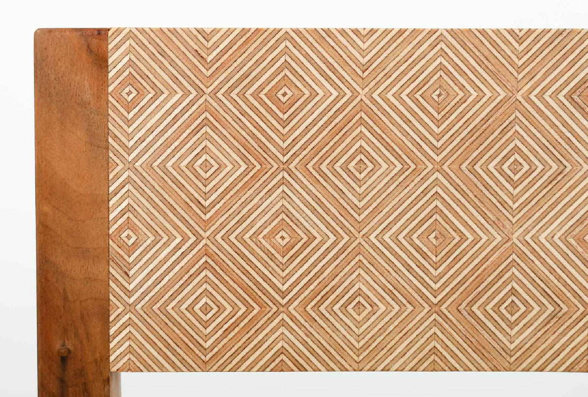Détail du dossier : tissu beige à motif chevrons avec encadrement en bois brun.