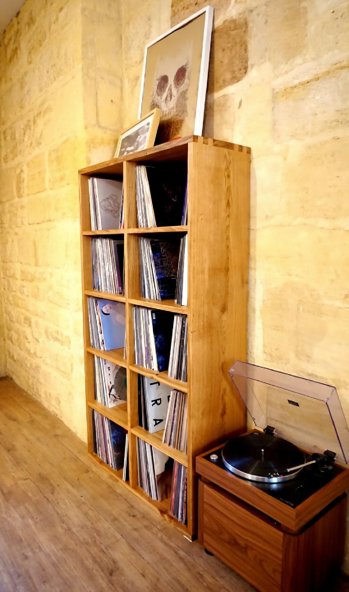 Bibliothèque pour vinyles en bois, vue de côté avec cases et disques visibles.