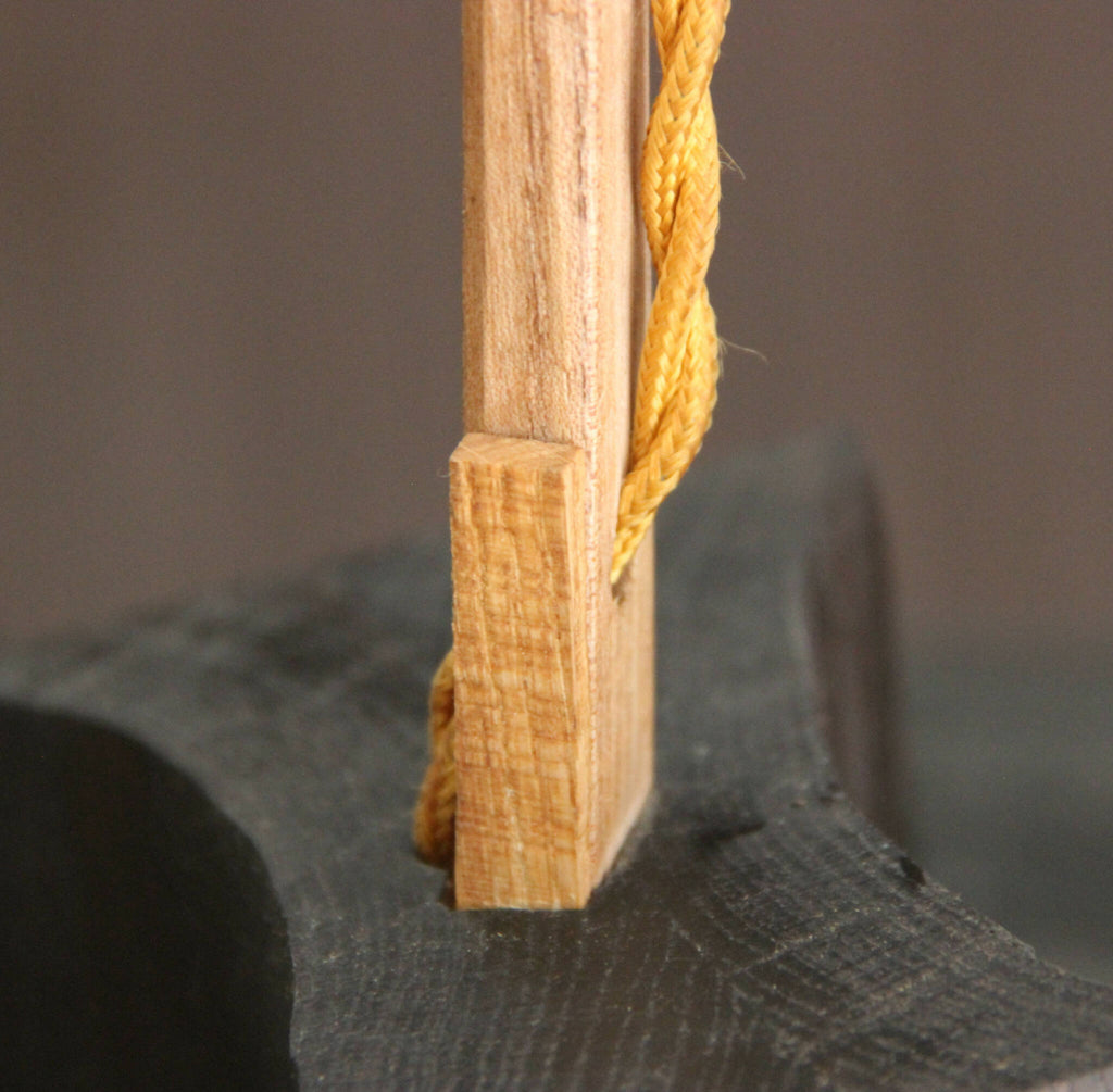 Fixation de corde dorée sur poteau en bois, nœud et tressage