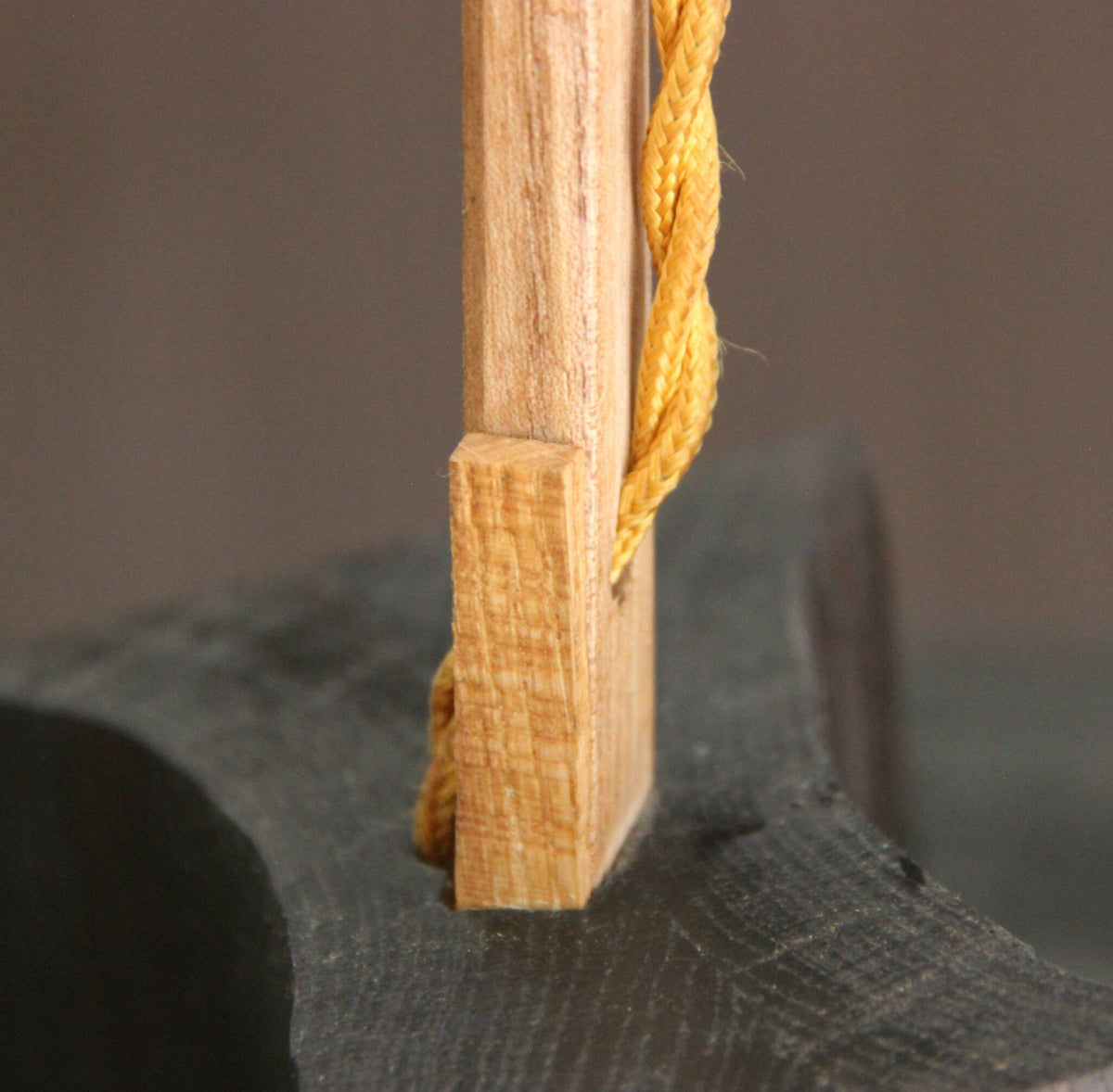 Fixation de corde dorée sur poteau en bois, nœud et tressage