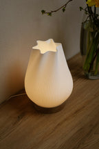 Lampe d’intérieur à abat-jour blanc côtelé et base en bois, éclairage doux allumé.