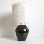 Lampe Puntia avec base noire brillante et abat-jour cylindrique en tissu blanc ajouré