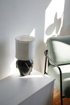 Lampe Puntia à abat-jour blanc cylindrique ajouré et base noire brillante