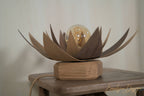 Lampe lotus en bois brun avec ampoule sphérique sur socle, vue de côté