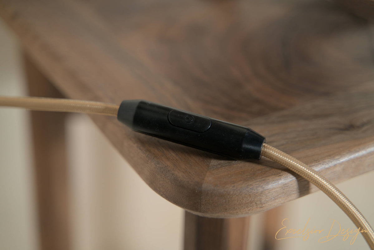 Interrupteur noir sur câble pour lampe, détail près du bois