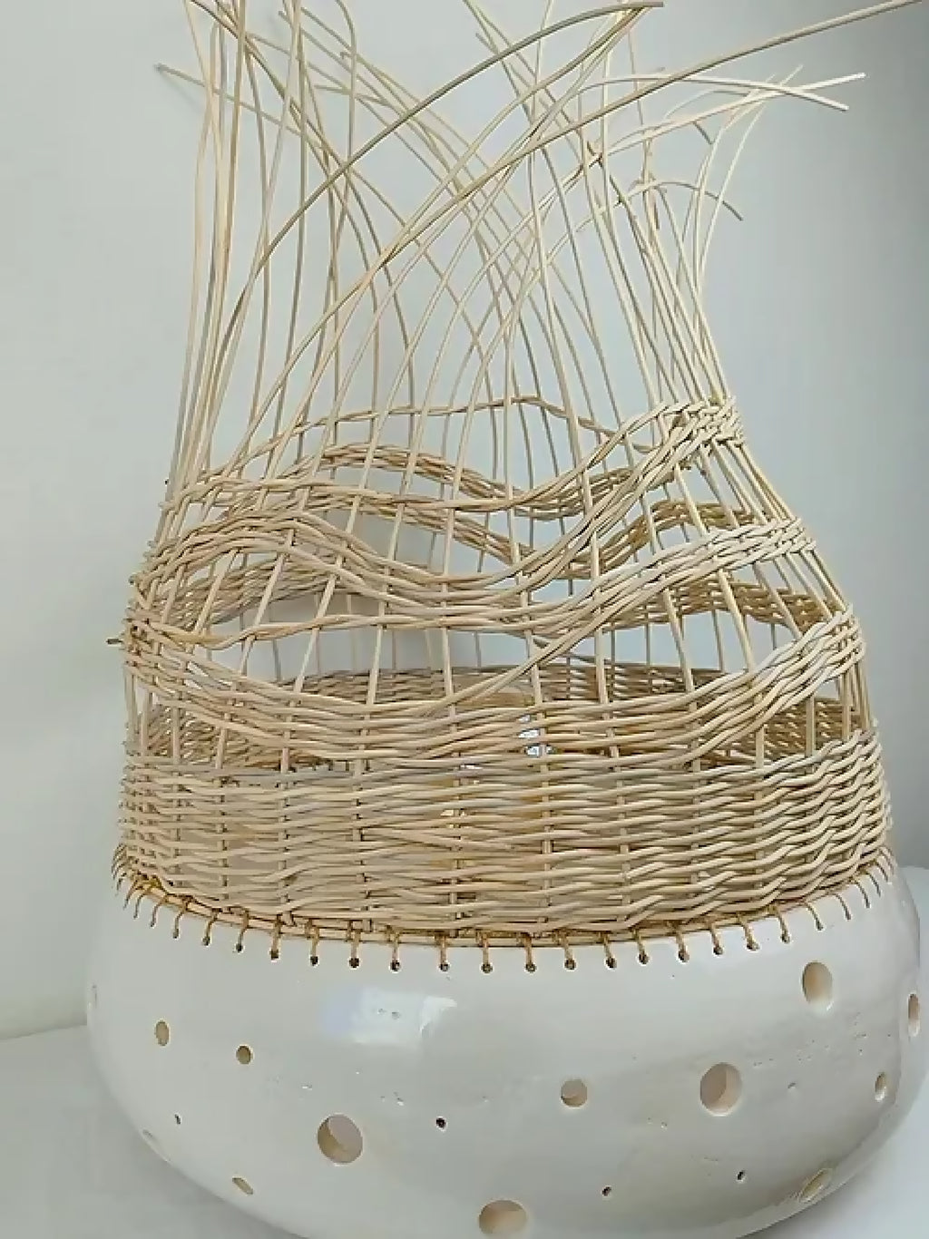 Lampe à poser en tressage beige clair, base blanche ajourée, abat-jour en cloche.