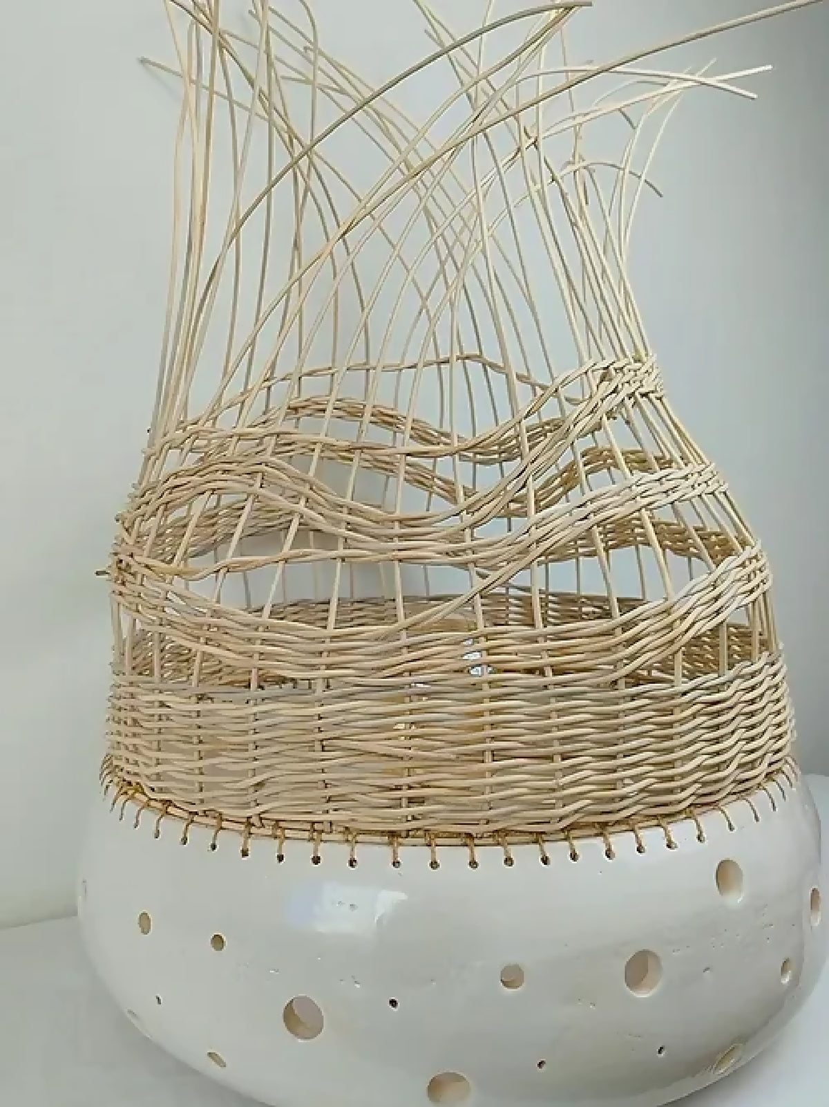 Lampe à poser en tressage beige clair, base blanche ajourée, abat-jour en cloche.