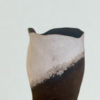 Vase en céramique noir et clair, ouverture échancrée sur le dessus, surface texturée