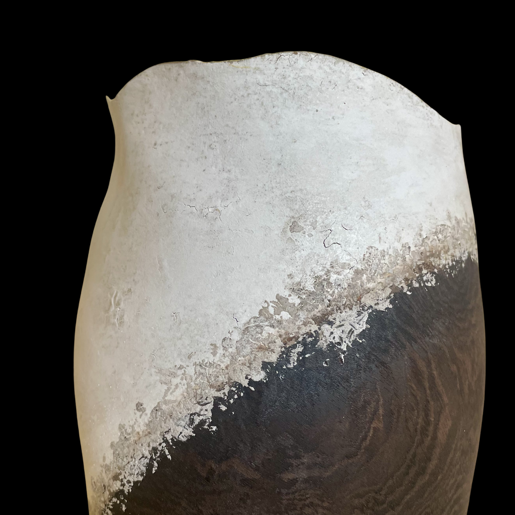 Vase noir et clair, gros plan : diagonale blanchie, surface patinée et éclats texturés