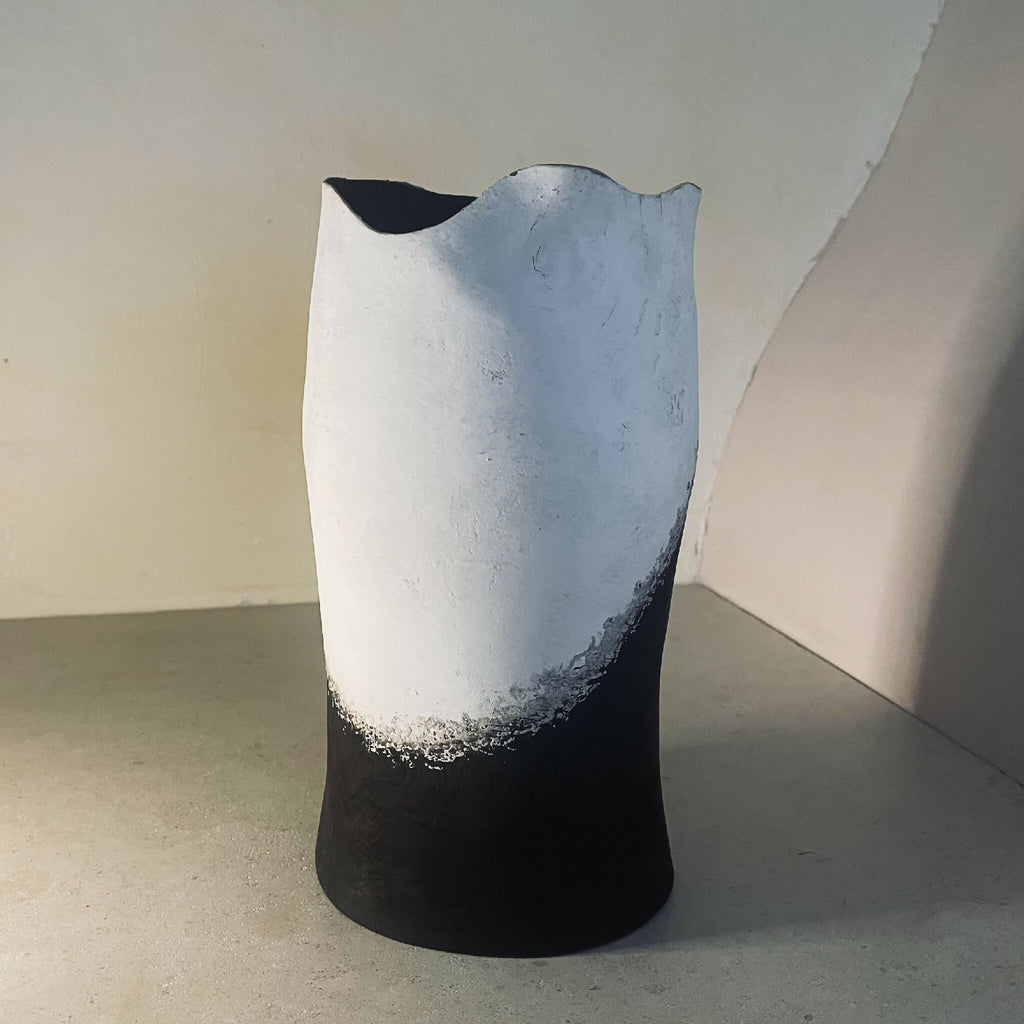 Vase en céramique bicolore blanc et noir, bord découpé et ouverture asymétrique