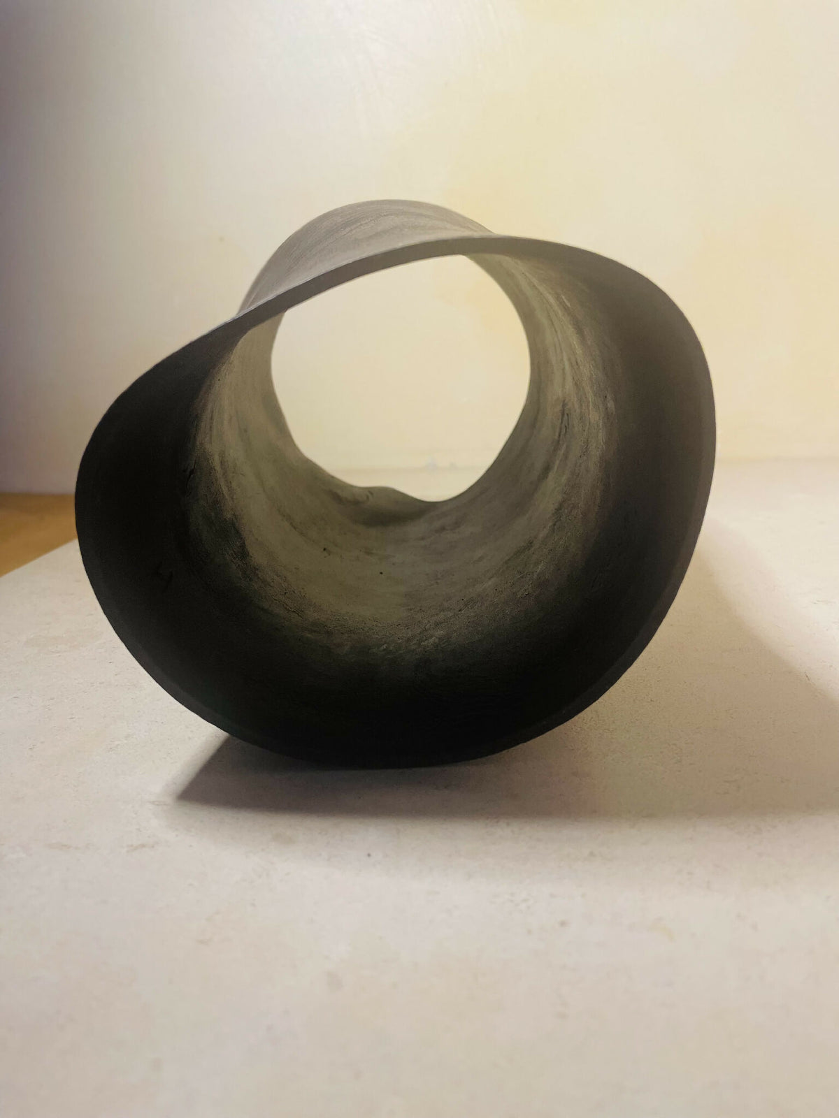 Vase cylindrique noir, ouverture circulaire sur le dessus, intérieur gris