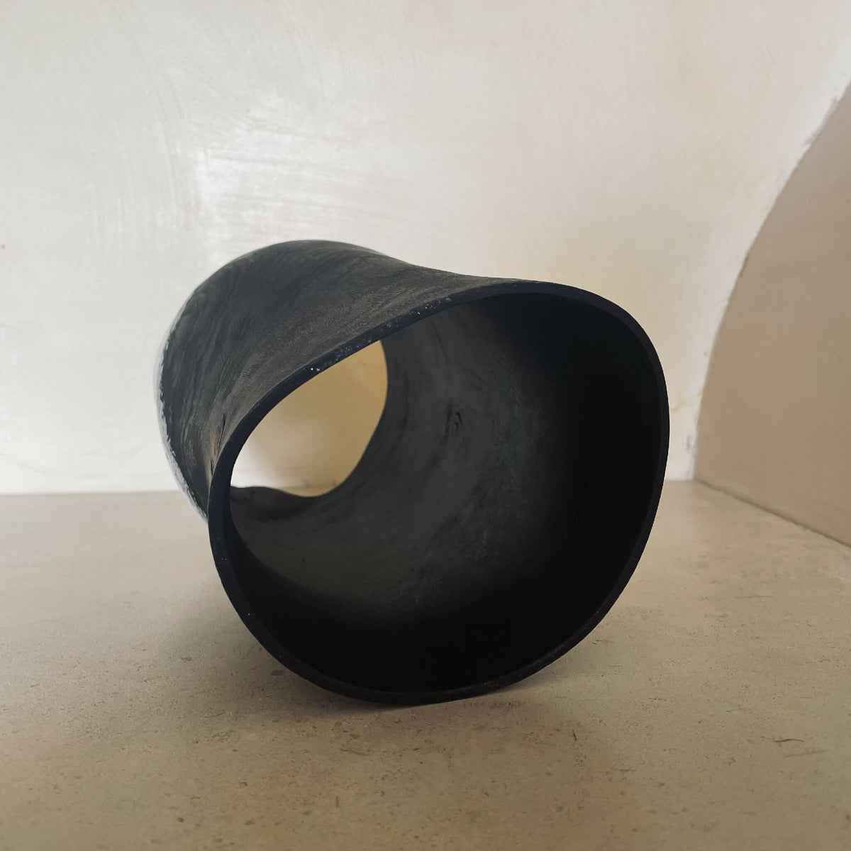 Vase cylindrique noir, ouverture latérale en forme de demi-cercle, finition mate texturée