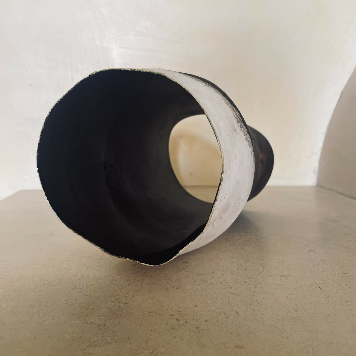 Vase noir bicolore, vue de profil de l’ouverture circulaire, finition mate irrégulière
