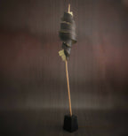 Lampe sur pied : spirale de rubans métalliques sombres sur tige bois, base carrée noire