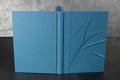 Carnet bleu à reliefs, couverture texturée avec motif en relief, pages ouvertes