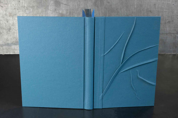 Carnet bleu à reliefs, couverture texturée avec motif en relief, pages ouvertes