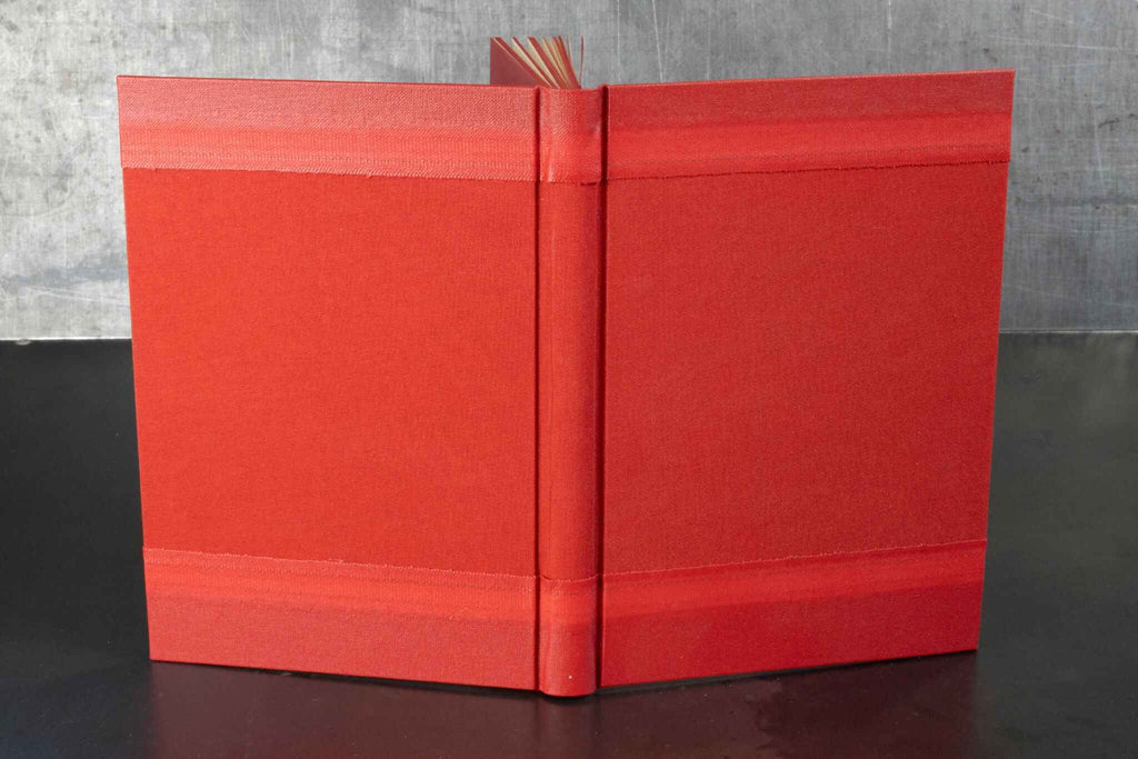 Carnet ou livre d’or rouge monochrome, couverture rigide et tranche centrale visible