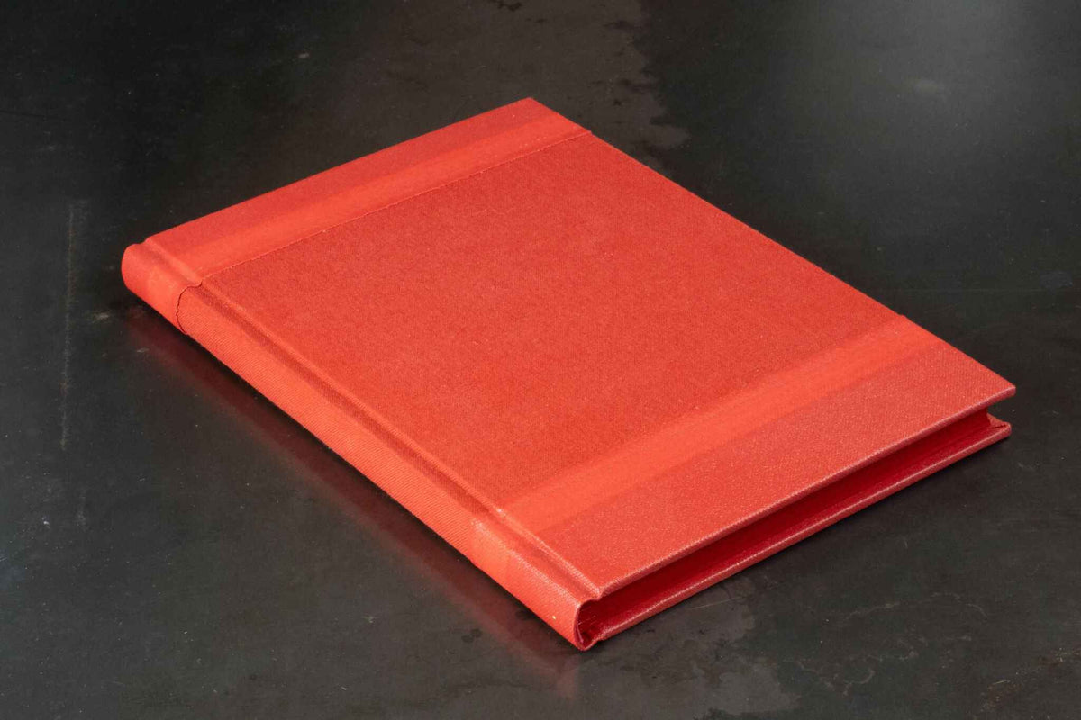 Livre d’or rouge monochrome, couverture rigide fermée, vue en biais