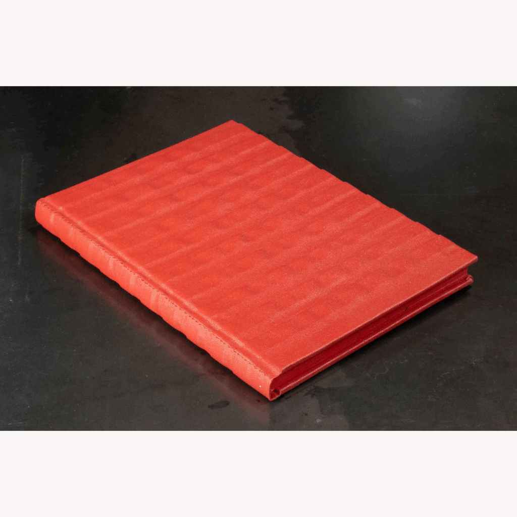 Carnet rouge à reliefs, couverture fermée vue en perspective