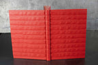 Carnet rouge à reliefs, couverture ouverte avec dos au centre
