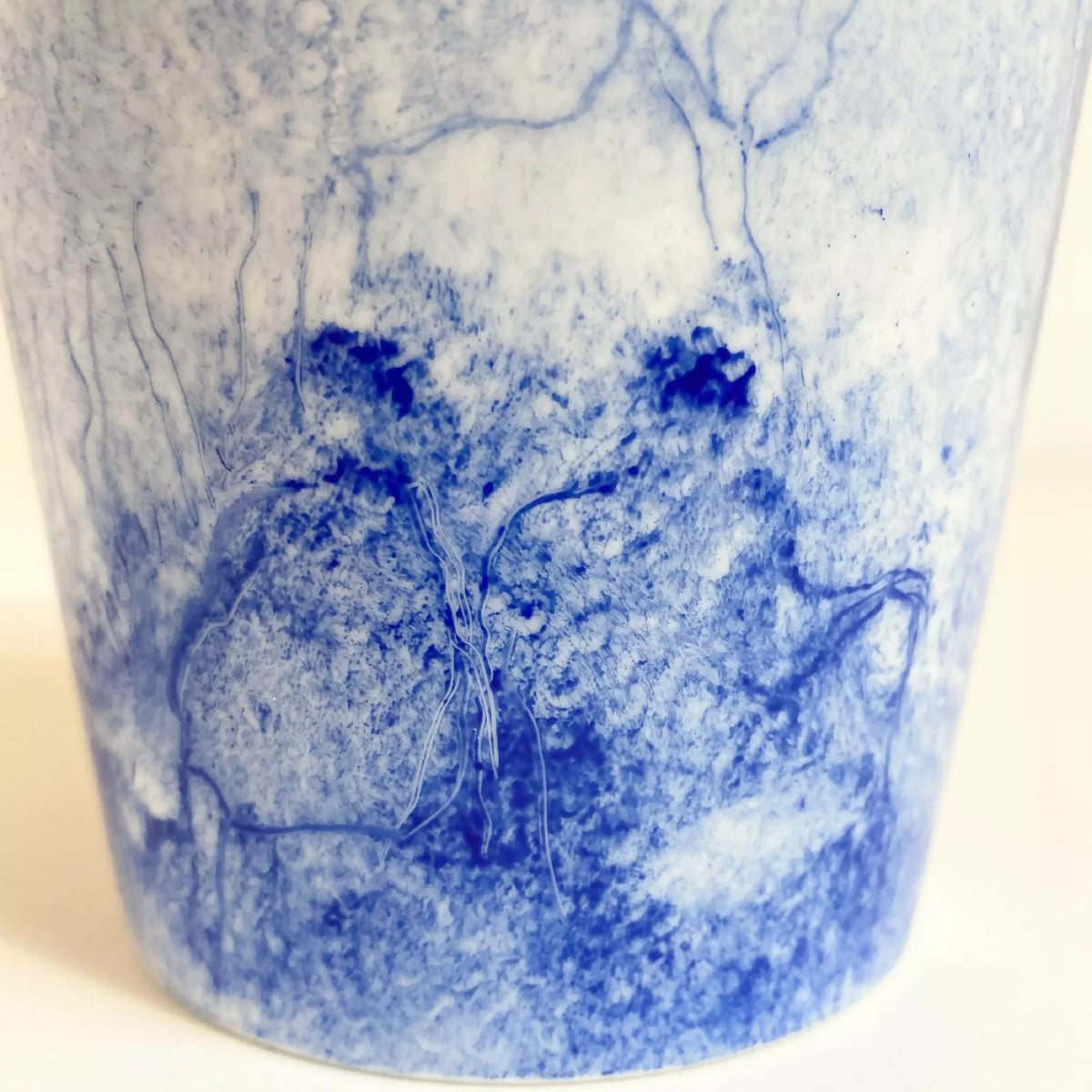 Mug en céramique blanc, gros plan décor paysage bleu avec branches et nuages