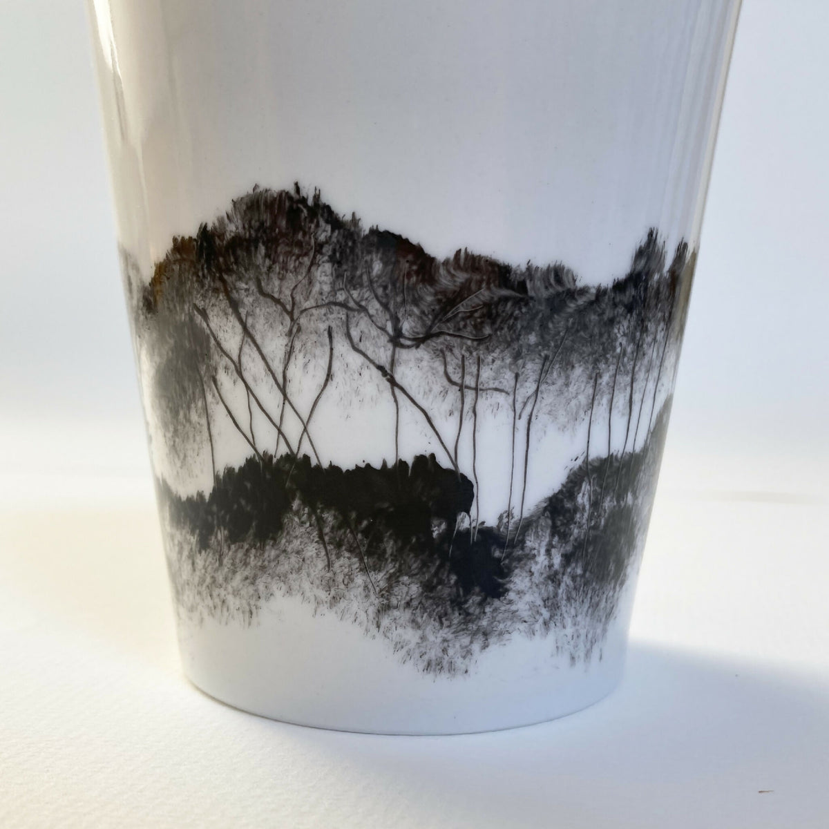 Mug en porcelaine blanc, bas du décor paysage en aplats noirs et gris