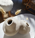 Peluche décorative blanche vue de dessus, museau sculpté et pattes visibles sur le sol.