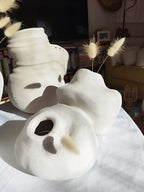 Peluche décorative blanche en forme d’animal, profil avec oreilles et museau en relief.