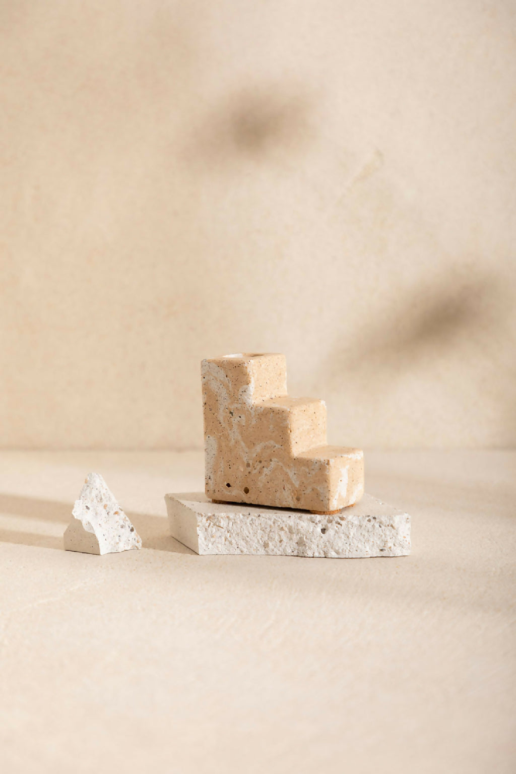 Bougeoir à base en blocs beige sable, socle en pierre claire texturée, sans bougie