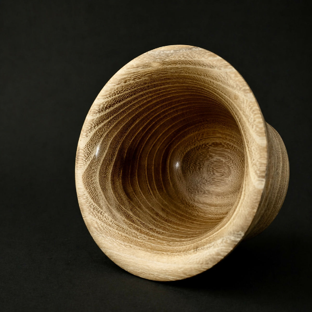 Gobelet en céramique beige, intérieur texturé en spirales concentriques.
