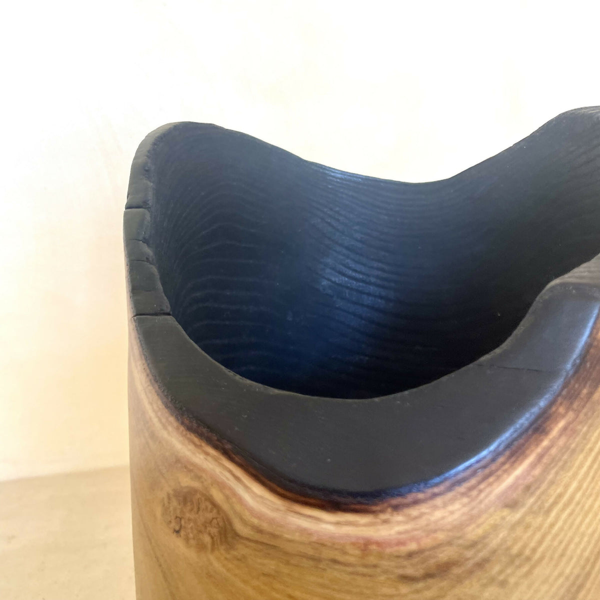 Bord du pot en bois et intérieur noir profond, surface lisse