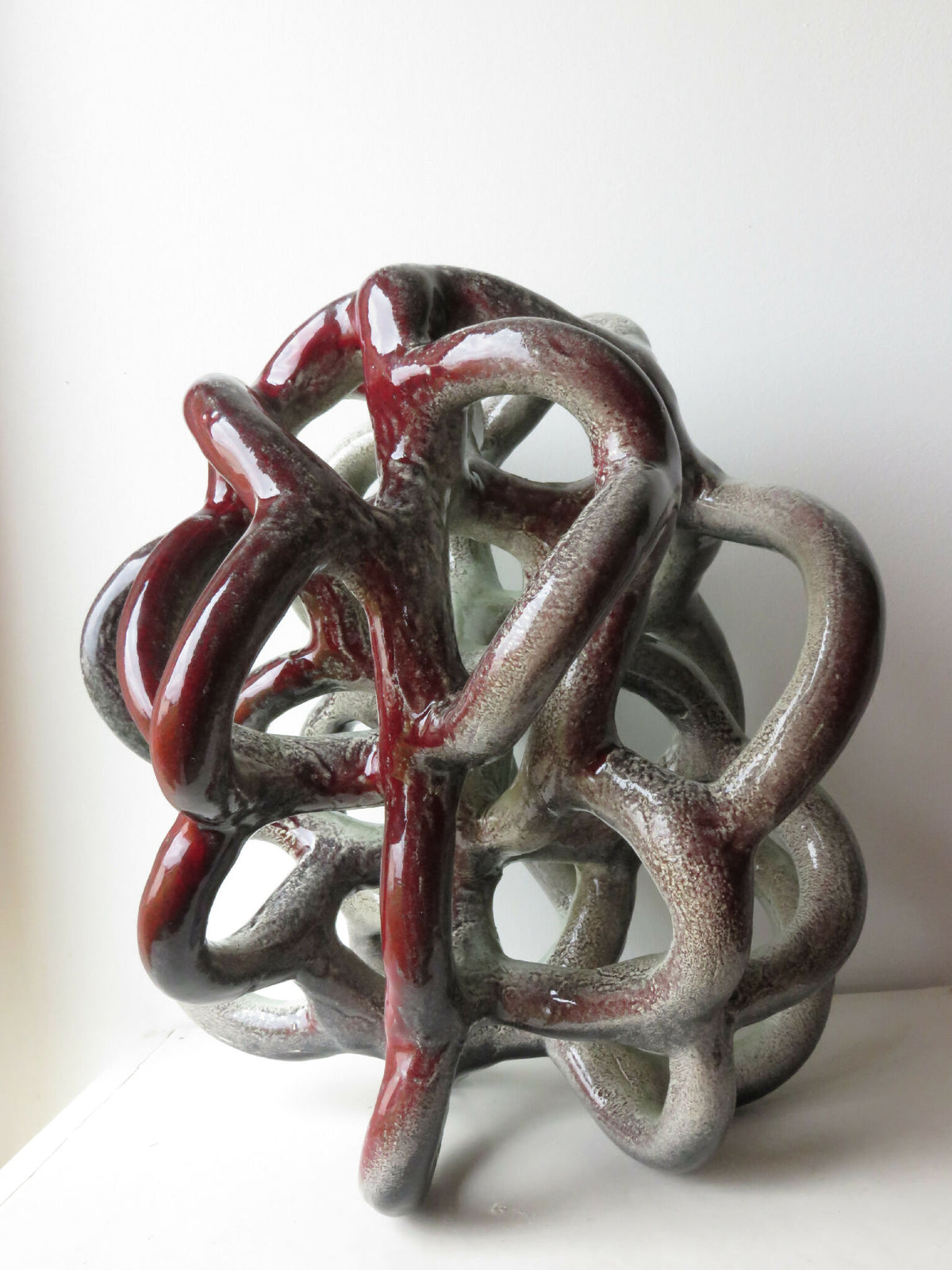 Sculpture décorative Nodulus en métal gris et rouge, nœud enchevêtré.