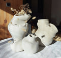 Décor en forme de masque blanc ajouré, avec fleurs séchées et brins duveteux