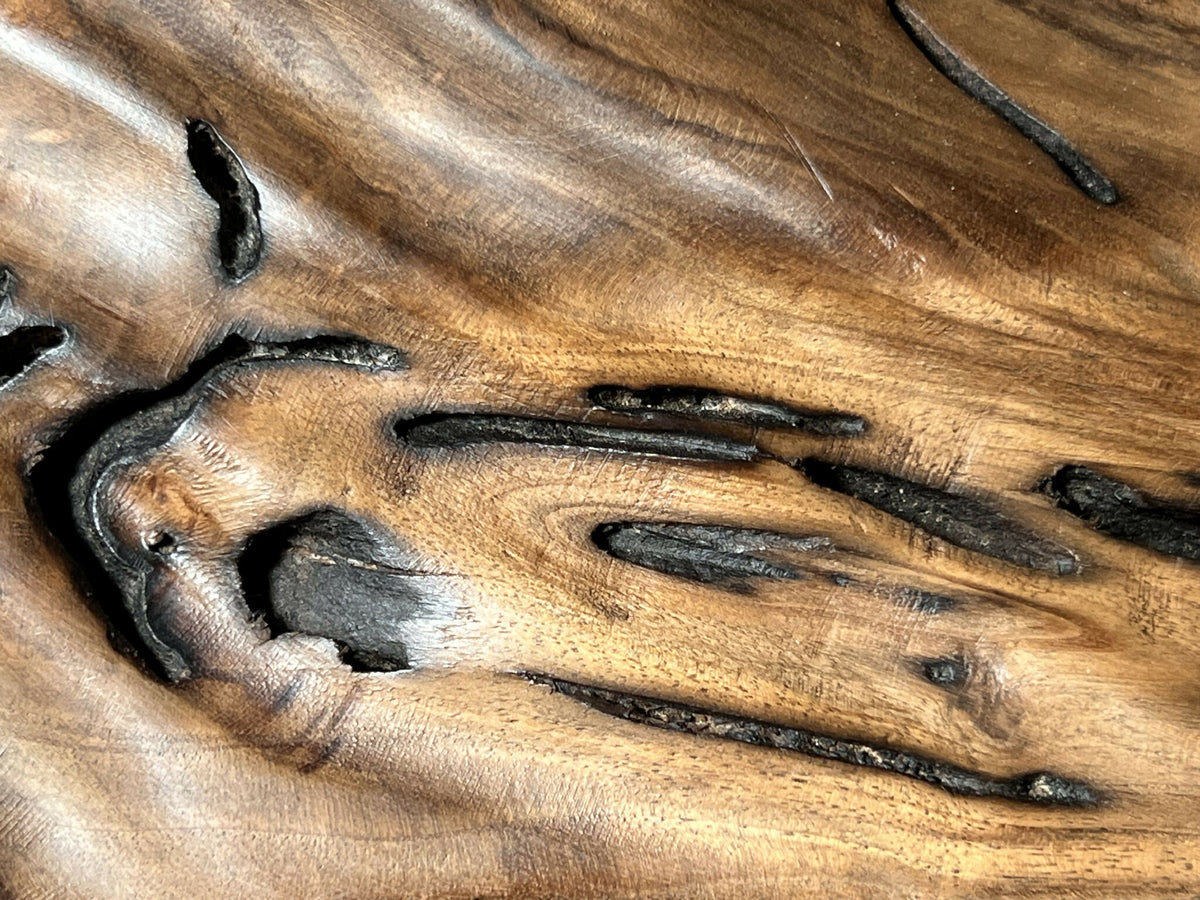 Détail rapproché : figure abstraite et lignes noires sur surface texturée couleur bois