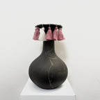 Soliflore noir en forme de vase avec pompons rose et blancs sur le col