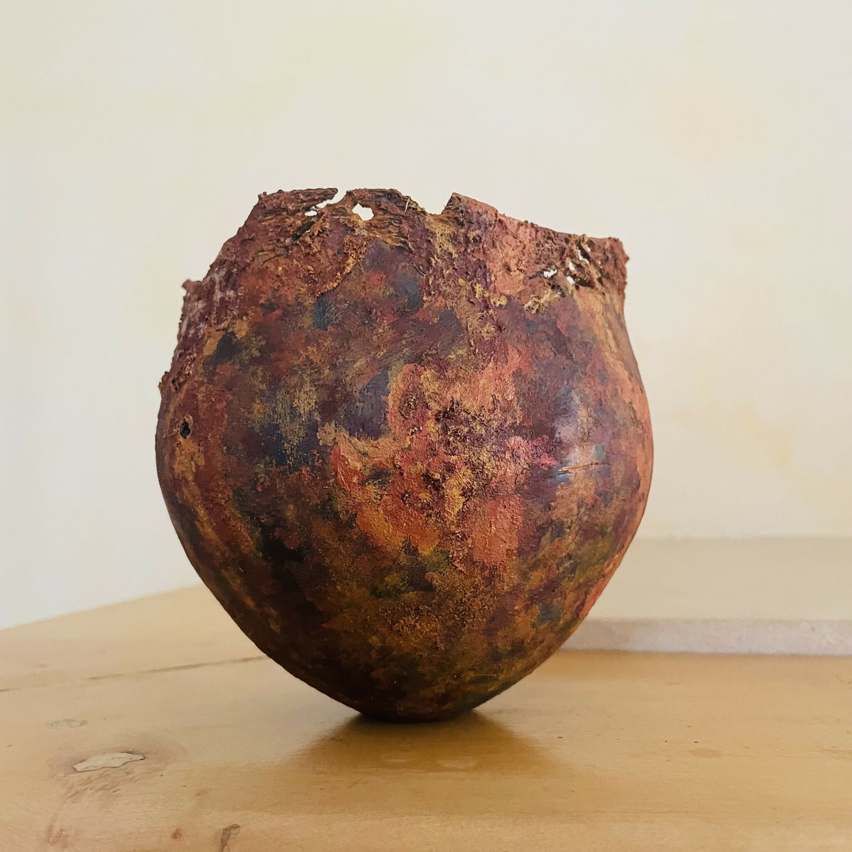 Vase en métal oxydé brun rouge, surface irrégulière, forme évasée vers le haut.