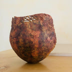 Vase en métal oxydé brun rouge, rebord ébréché, décolorations par taches.