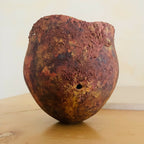 Vase en métal oxydé brun rouge, surface texturée, petit trou sur le côté.
