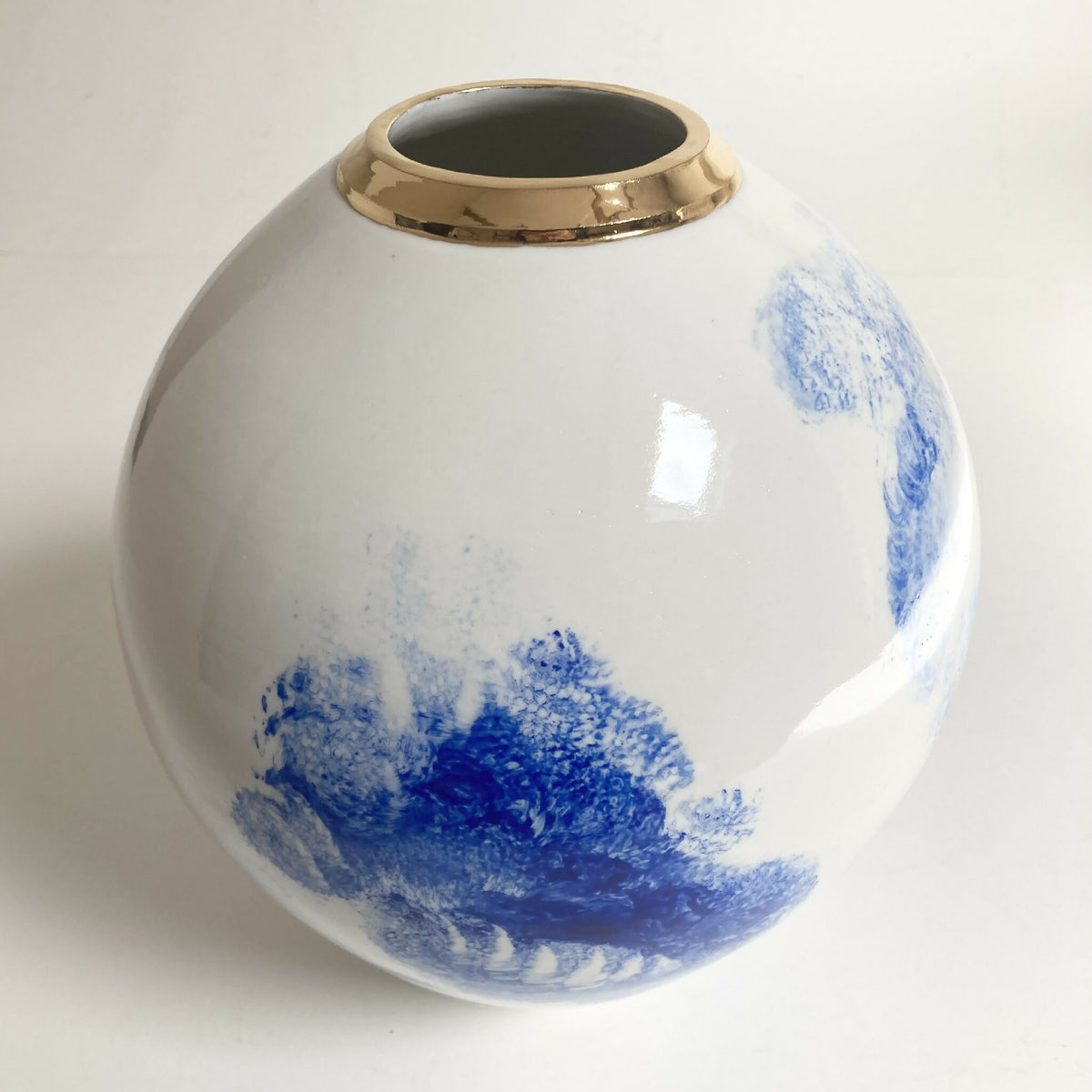 Vase boule blanc avec décor bleu diffus et col doré