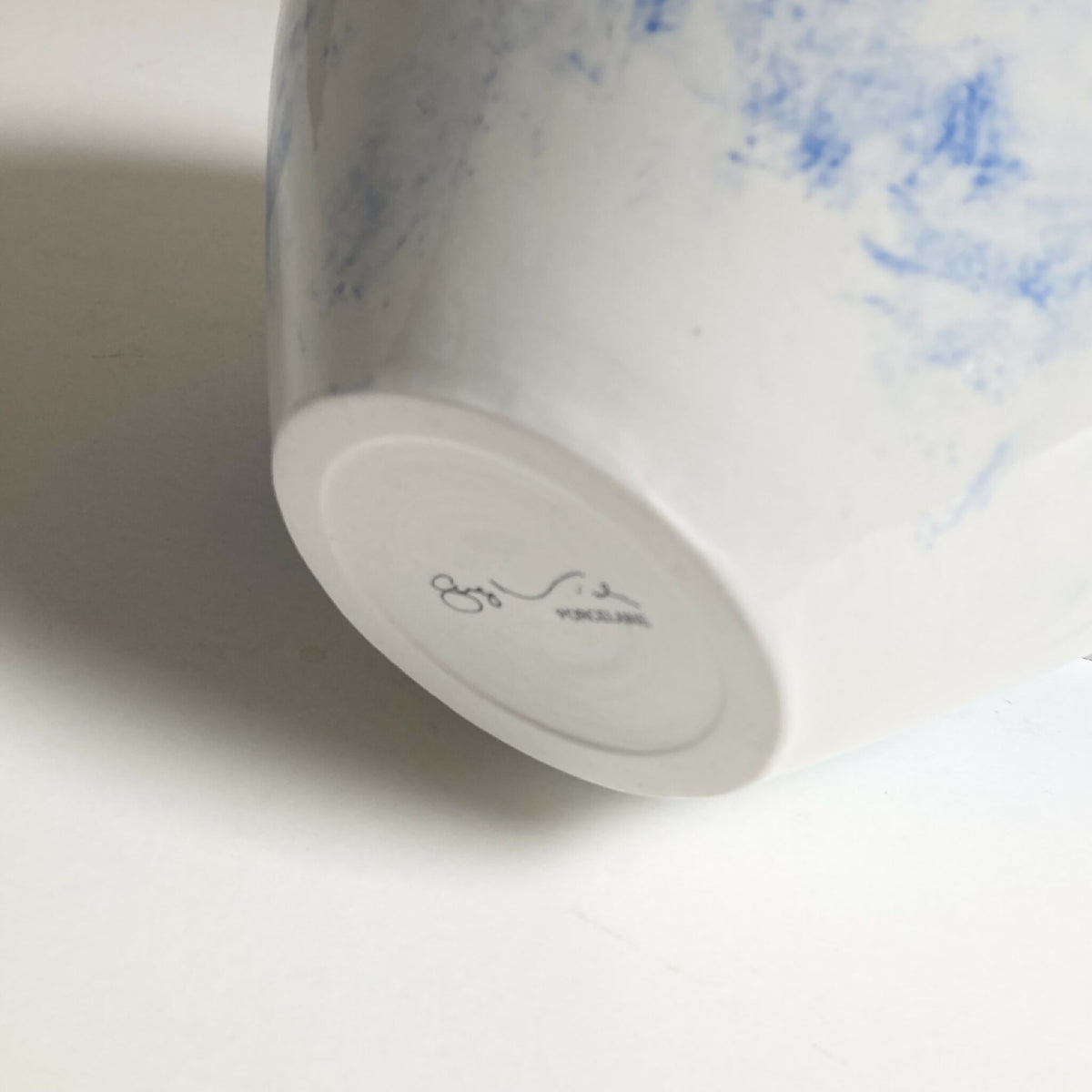Base du vase blanc avec signature gravée et décor bleu sur le côté