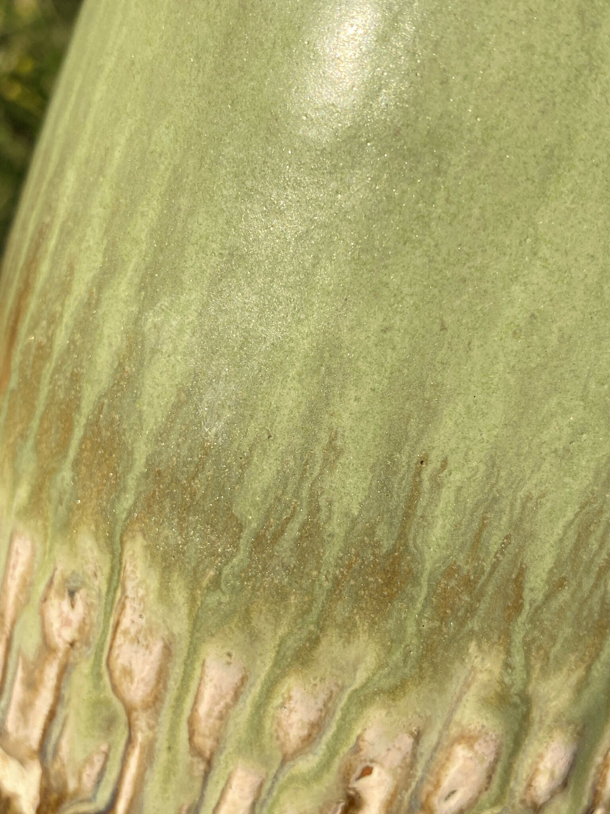 Vase en céramique vert clair, texture striée et taches beige, glaçure brillante.