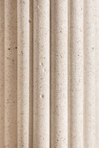 Vase en céramique blanche texturée, stries verticales et éclats décoratifs.