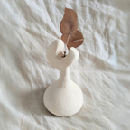 Vase en céramique blanche avec tige florale et feuilles brunes séchées