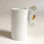 Vase cylindrique blanc avec hippocampe en relief et accents dorés sur le côté