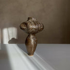 Vase sculptural brun foncé tacheté, silhouette arrondie et long goulot