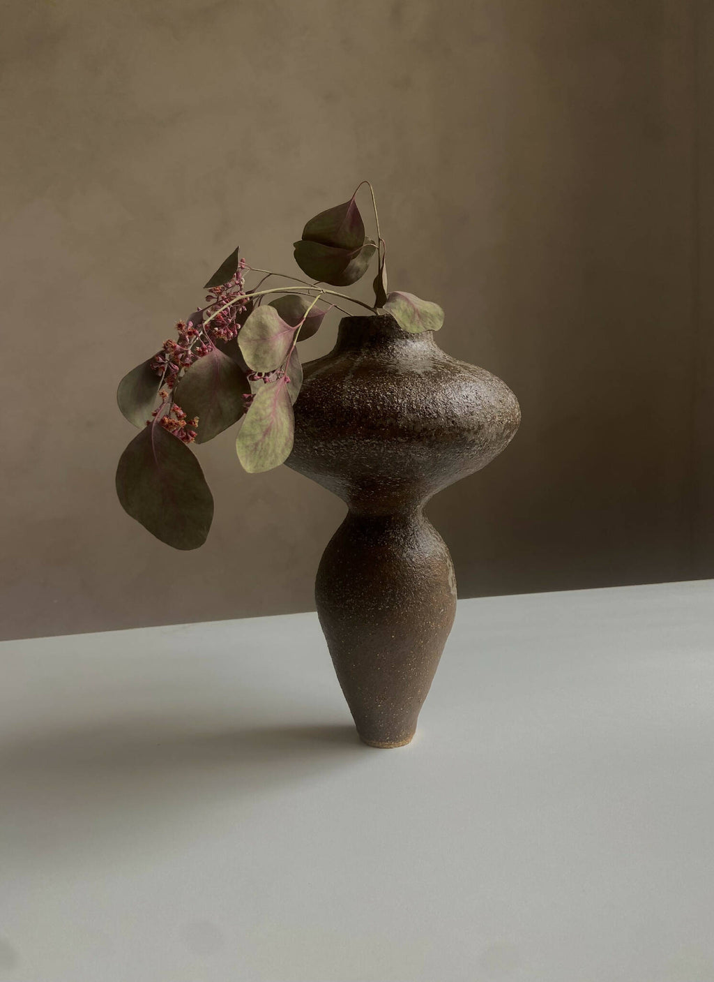 Vase sculptural brun foncé tacheté avec fleurs séchées à tige