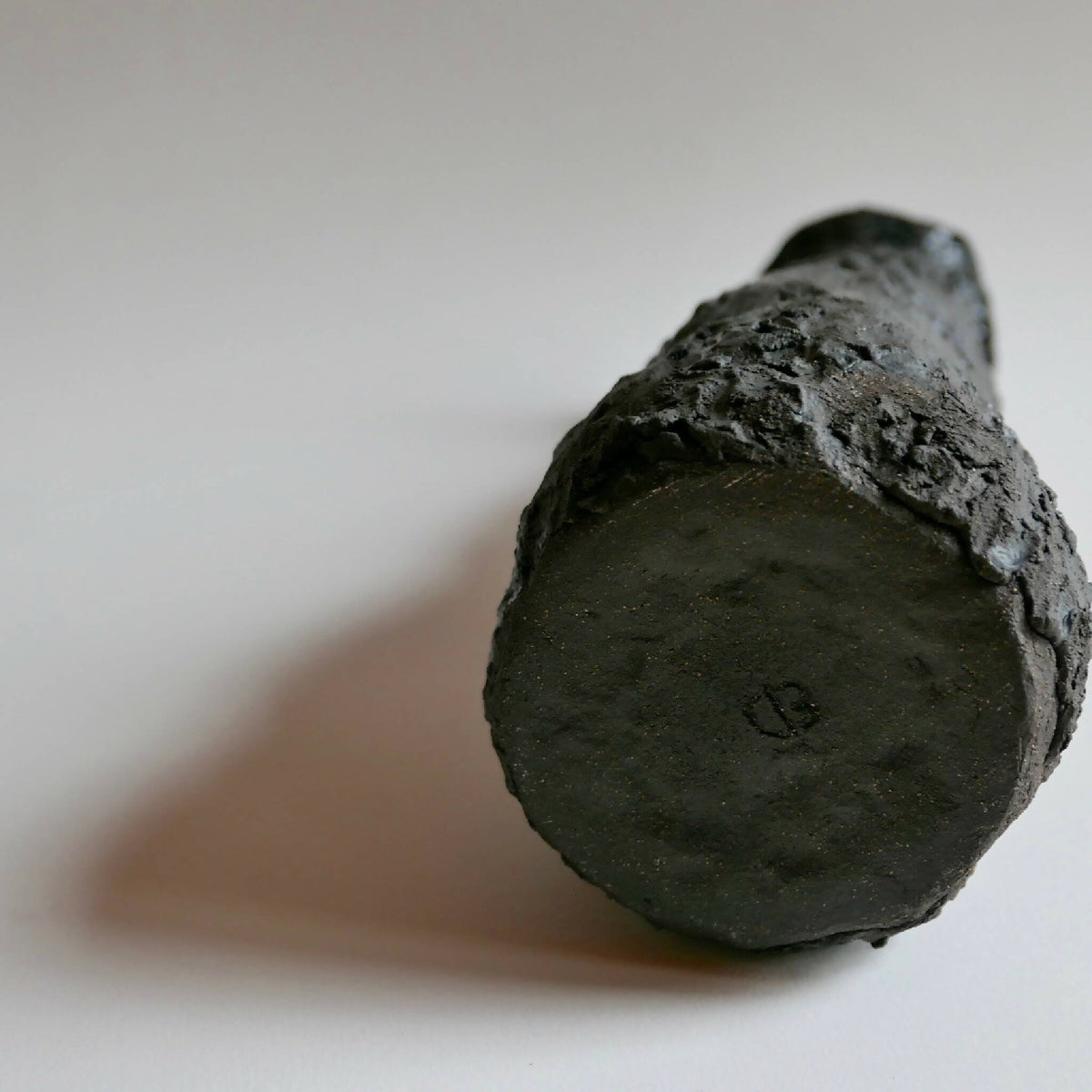 Vase MAGMA : base ronde sombre, surface irrégulière texturée
